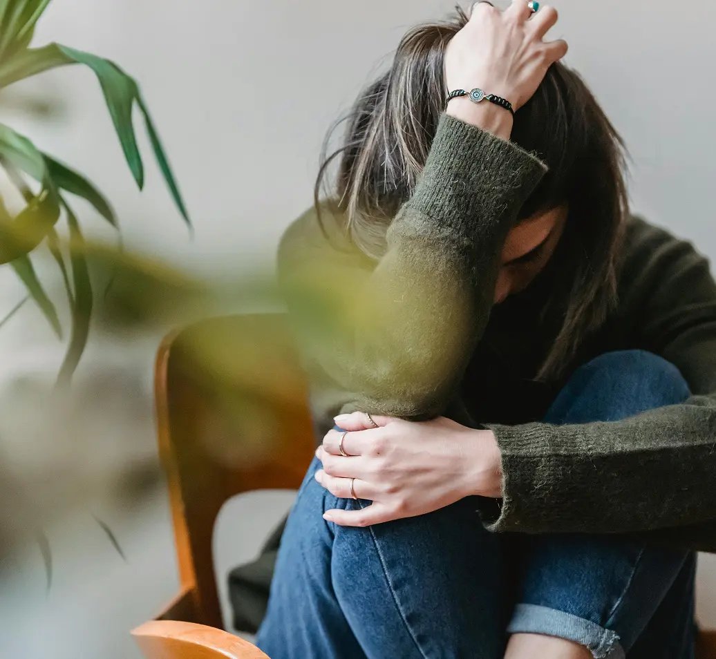A person sitting with their head in their hands