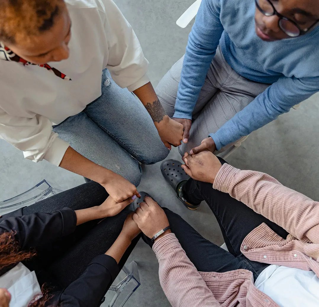 A group of people with hands joined, suggesting shared support